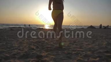 可爱的小女孩在热带海滩上<strong>奔跑</strong>。 快乐的孩子在美丽的夕阳下<strong>奔跑</strong>的剪影。 孩子的脚